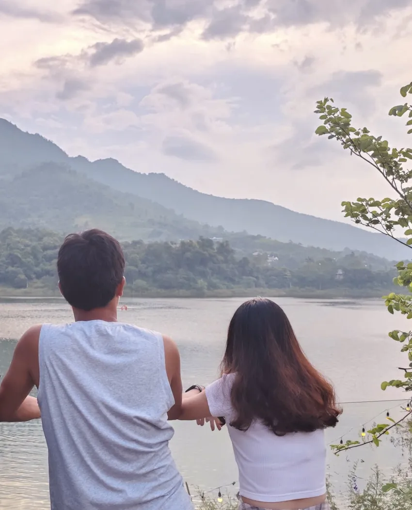 Hai vợ chồng ngồi cạnh nhau bên hồ